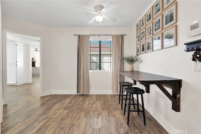 dining area with wood-type flooring and ceiling fan