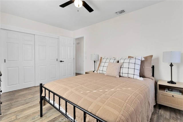 bedroom with hardwood / wood-style flooring, ceiling fan, and a closet