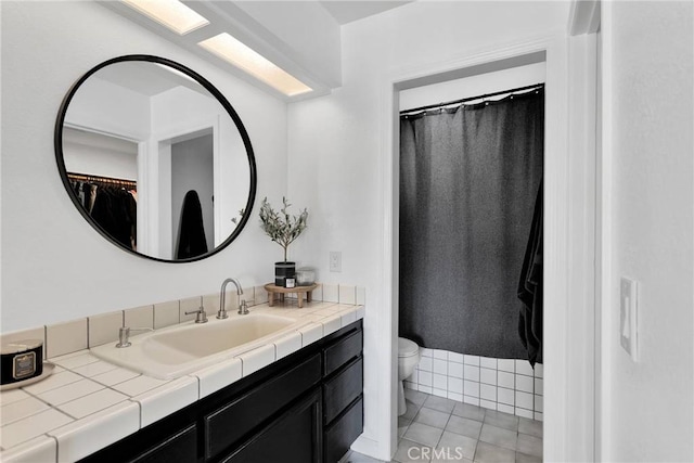 bathroom with toilet, vanity, and tile patterned floors