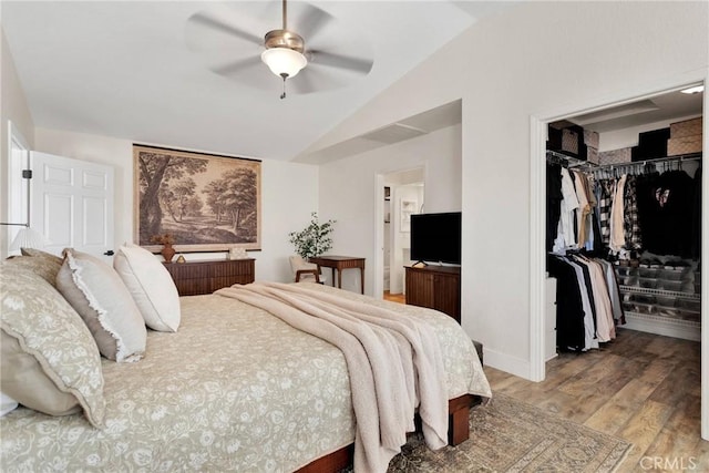 bedroom featuring lofted ceiling, ceiling fan, connected bathroom, wood-type flooring, and a closet