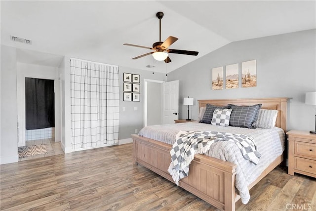 bedroom featuring ceiling fan, vaulted ceiling, and wood-type flooring