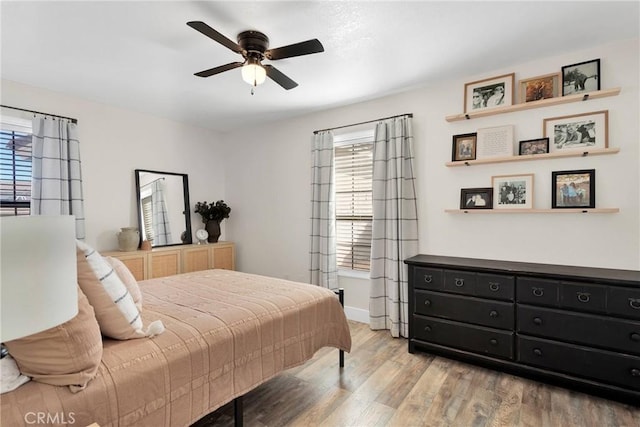 bedroom featuring multiple windows, ceiling fan, and light hardwood / wood-style floors