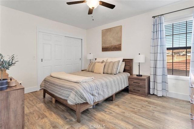 bedroom with a closet, ceiling fan, and light wood-type flooring