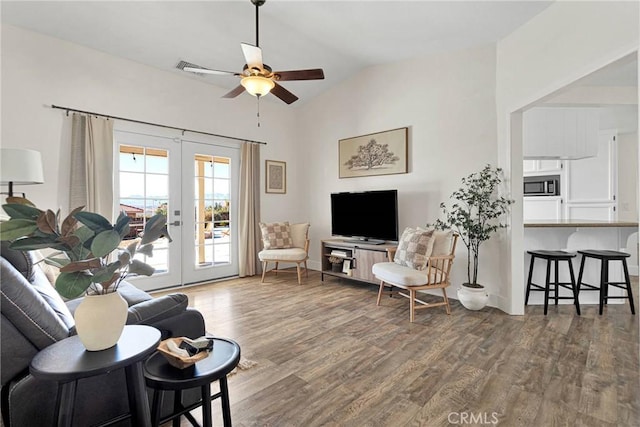 living room with french doors, dark hardwood / wood-style flooring, ceiling fan, and vaulted ceiling