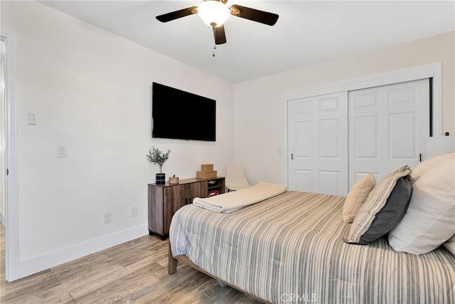 bedroom with ceiling fan, light hardwood / wood-style flooring, and a closet