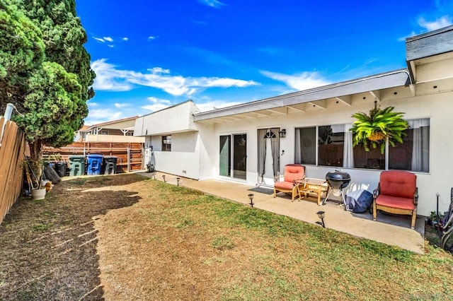 back of house featuring a patio and a yard