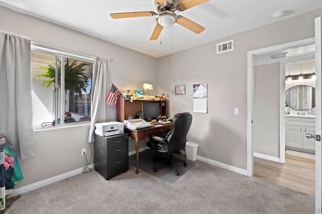 home office with light carpet and ceiling fan