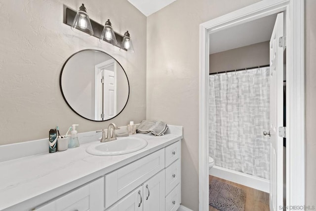 bathroom with hardwood / wood-style floors, vanity, and toilet