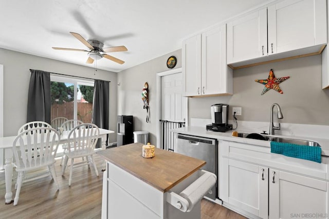 kitchen with white cabinets, stainless steel dishwasher, light hardwood / wood-style floors, and sink