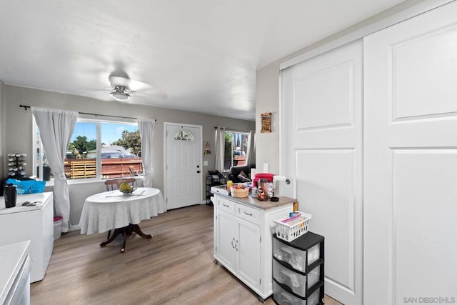 kitchen with white cabinets, ceiling fan, and light wood-type flooring