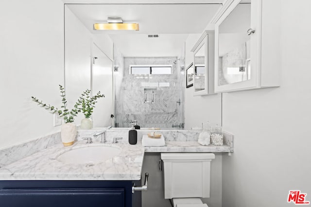 bathroom with vanity, a shower with shower door, and toilet