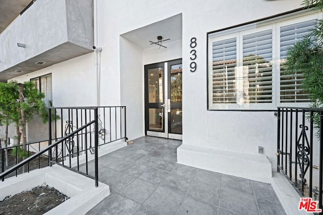 entrance to property with ceiling fan and french doors