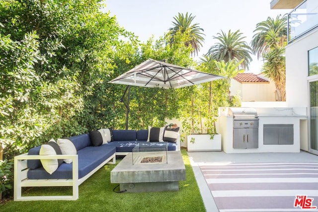 view of patio / terrace featuring an outdoor kitchen, an outdoor living space with a fire pit, and area for grilling