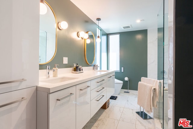 bathroom featuring a shower with door, vanity, and toilet