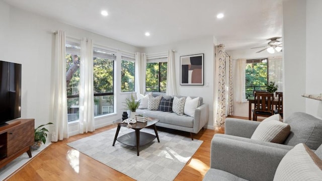 living room with light hardwood / wood-style floors and ceiling fan