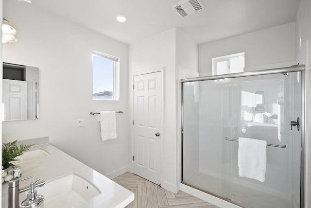 bathroom with vanity, walk in shower, and parquet floors