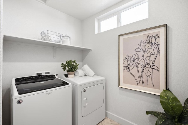 washroom with light parquet floors and washing machine and clothes dryer