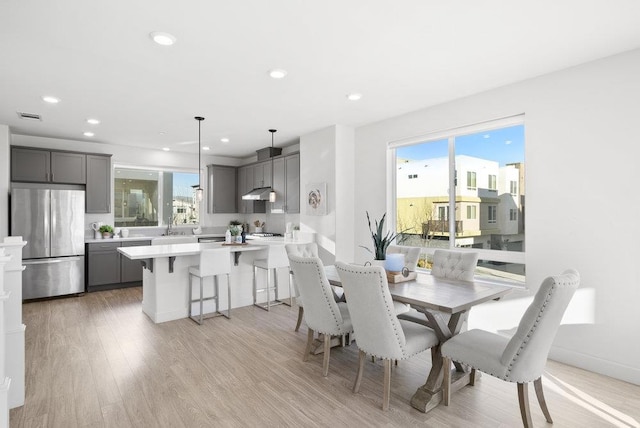 dining area featuring light hardwood / wood-style floors, a healthy amount of sunlight, and sink