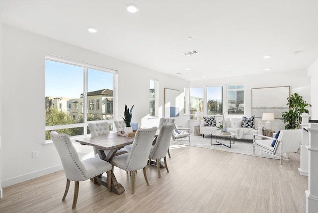 dining room with light hardwood / wood-style flooring and a healthy amount of sunlight