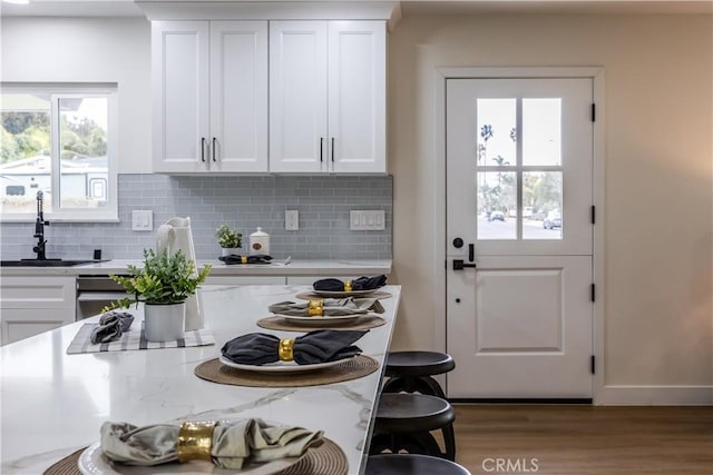 kitchen featuring sink, decorative backsplash, and white cabinets