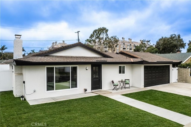 back of property with a garage and a lawn