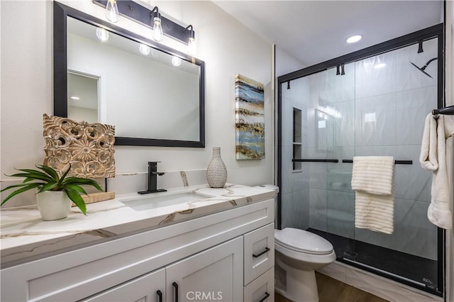 bathroom with vanity, toilet, and an enclosed shower