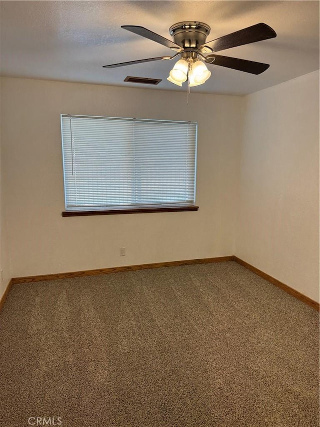 spare room featuring ceiling fan and carpet