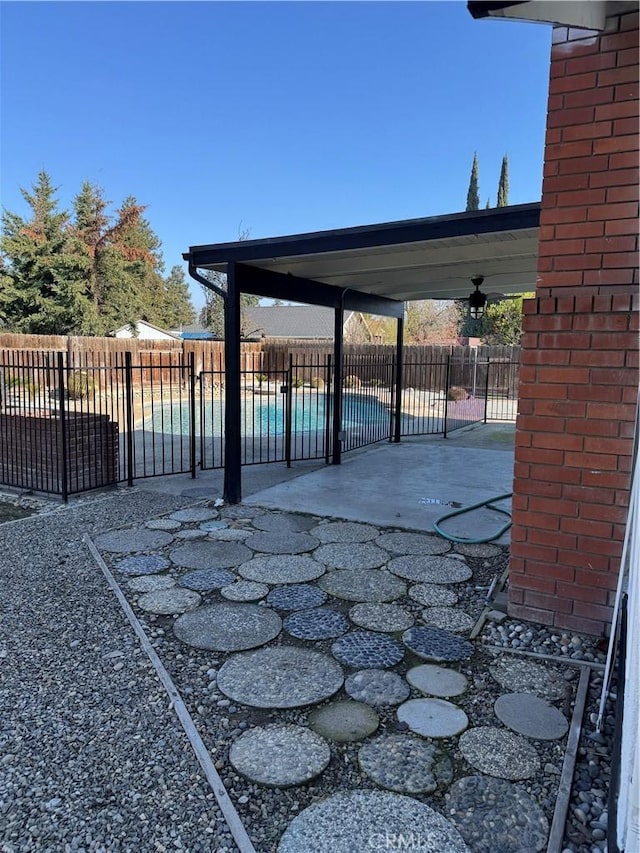 view of patio featuring ceiling fan and a fenced in pool