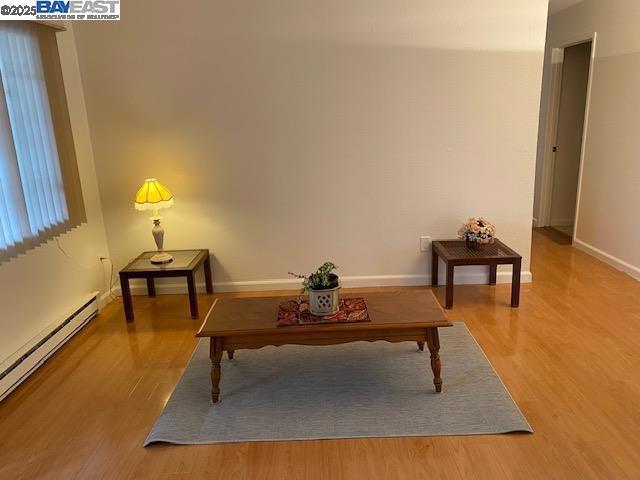 sitting room with wood-type flooring and baseboard heating