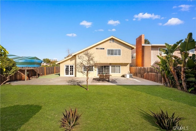 rear view of house with a patio, french doors, and a lawn