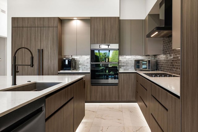 kitchen with sink, gas cooktop, dishwasher, wall chimney exhaust hood, and double oven