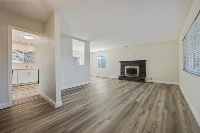 unfurnished living room with light wood-type flooring and sink