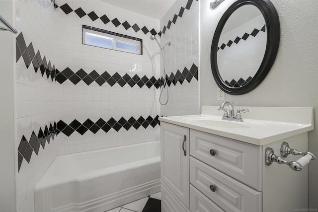 bathroom with tile patterned floors, vanity, and tiled shower / bath