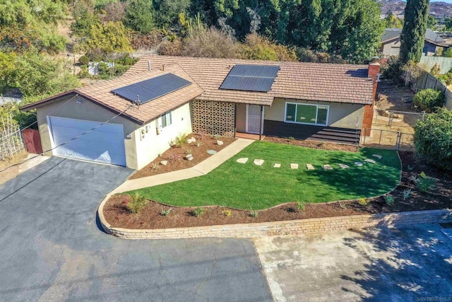 view of front facade featuring solar panels, a front lawn, and a garage