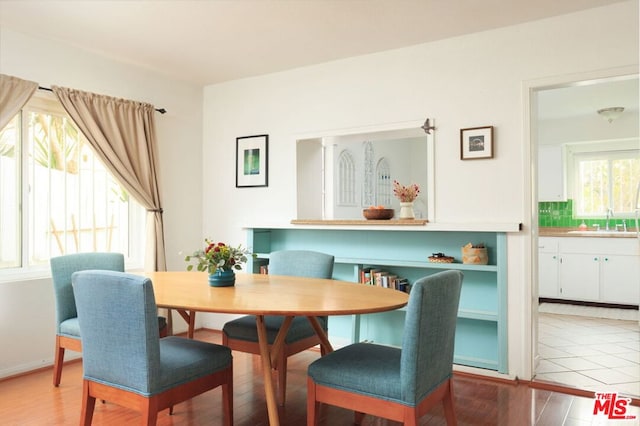 dining area with light wood-type flooring and sink