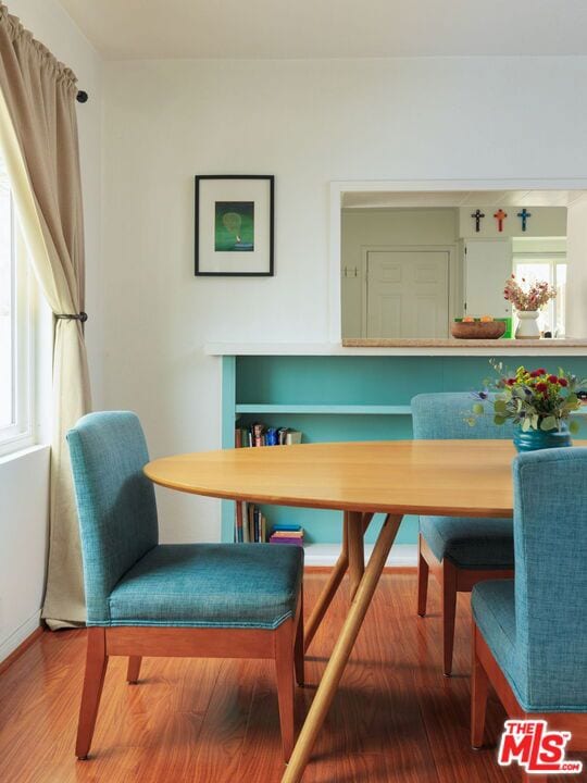 dining room featuring wood-type flooring and a healthy amount of sunlight