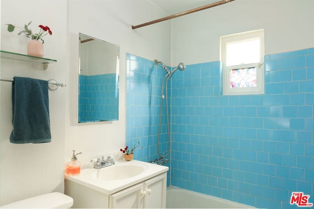 full bathroom with vanity, tiled shower / bath combo, and toilet