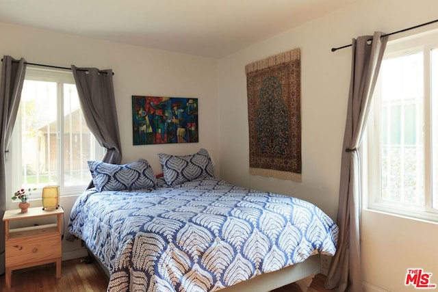 bedroom with hardwood / wood-style floors and multiple windows