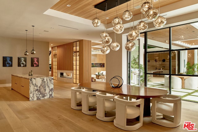 dining area featuring light wood-type flooring, wood ceiling, and wood walls