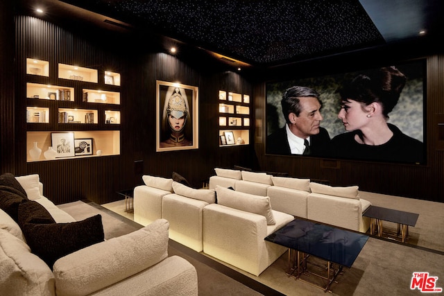 home theater room with wood walls, carpet floors, and built in shelves