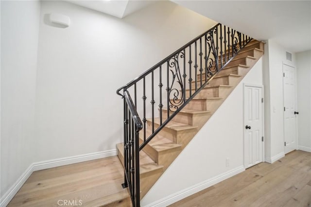 stairs featuring hardwood / wood-style floors