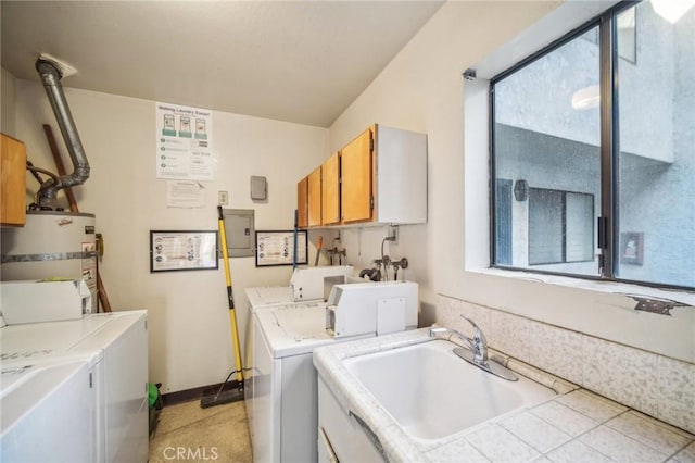 laundry area with washing machine and dryer, cabinets, strapped water heater, and sink