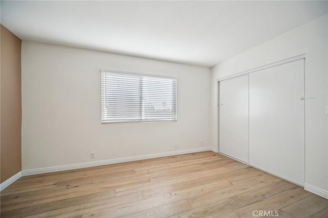 unfurnished bedroom featuring a closet and light hardwood / wood-style flooring