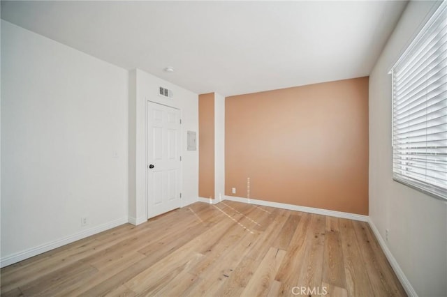 spare room featuring light hardwood / wood-style floors and plenty of natural light