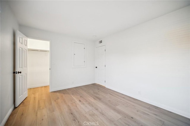 unfurnished bedroom with light wood-type flooring and a closet