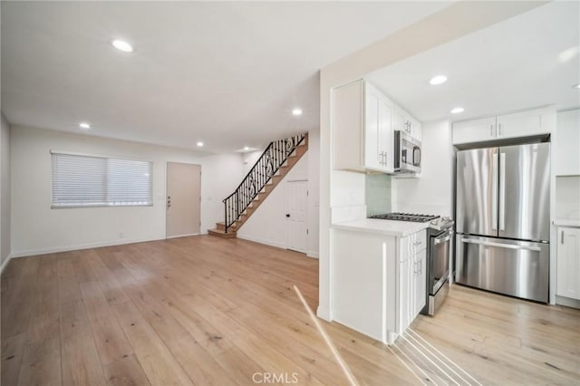 kitchen featuring light hardwood / wood-style floors, stainless steel appliances, and white cabinetry