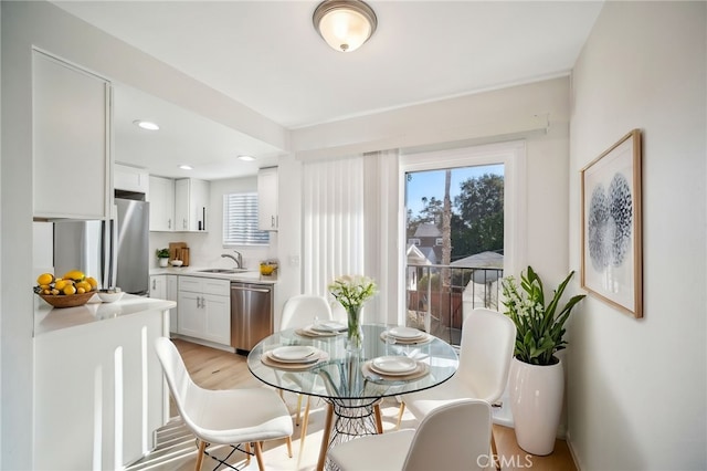 dining room featuring a healthy amount of sunlight, light hardwood / wood-style flooring, and sink