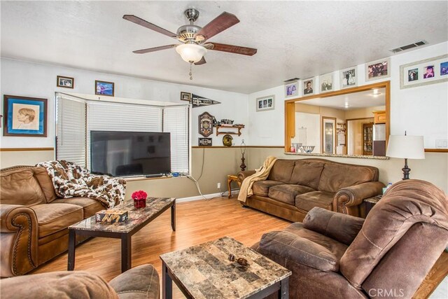 living room with ceiling fan and light hardwood / wood-style flooring