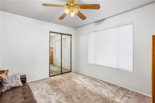 unfurnished bedroom featuring ceiling fan, a closet, and light carpet