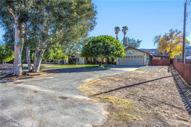 view of property hidden behind natural elements with a garage